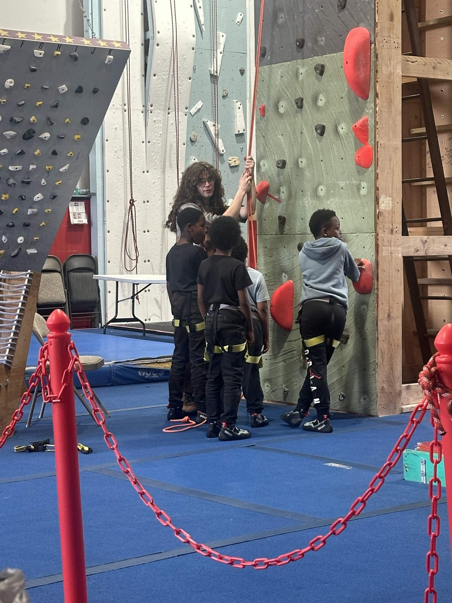 An instructor checking safety gear before a climb.